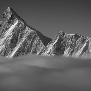 Panoramic picture of the Finsteraarhorn and the Agassizhorn. The summit of the Finsteraarhorn emerges from the sea of clouds after a time of snow.