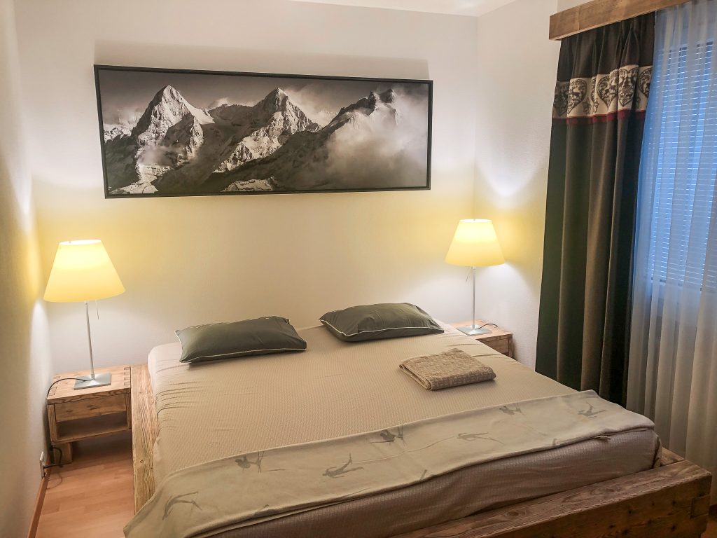 decoration of adult bedroom in mountain chalet style - large mountain picture
