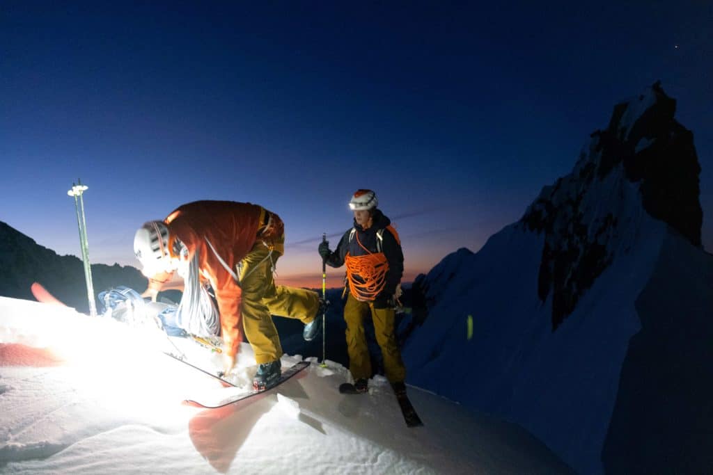 Vivian Bruchez, skieur de pente raide, en train de chausser ses skis en pleine nuit