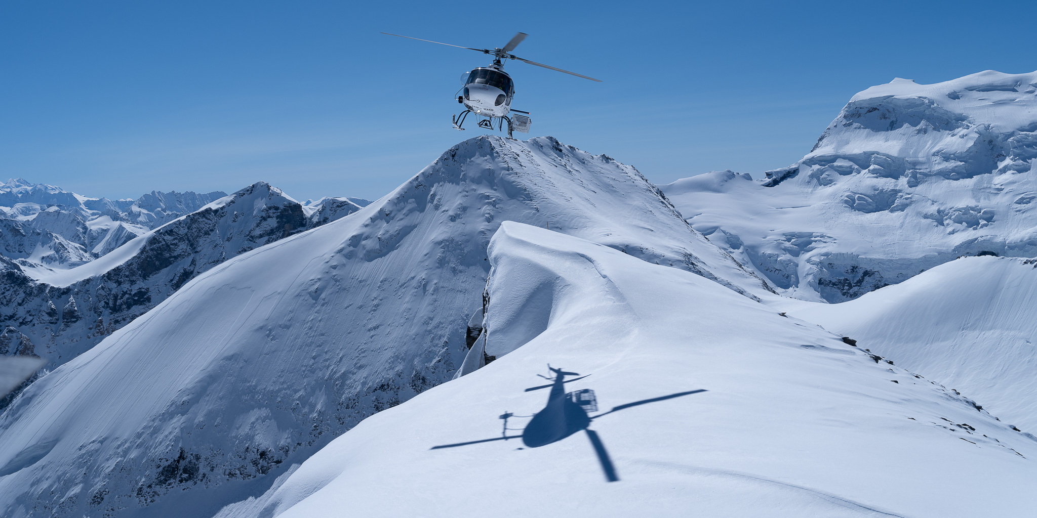 Hélicoptère survolant le Petit Combin pour déposer les skieurs en héliski