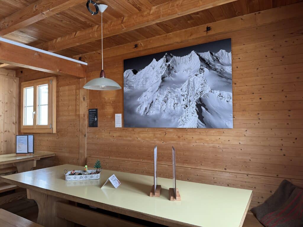 Intérieur de la Mischabelhuette avec œuvre de Thomas Crauwels accrochée sur le mur en bois