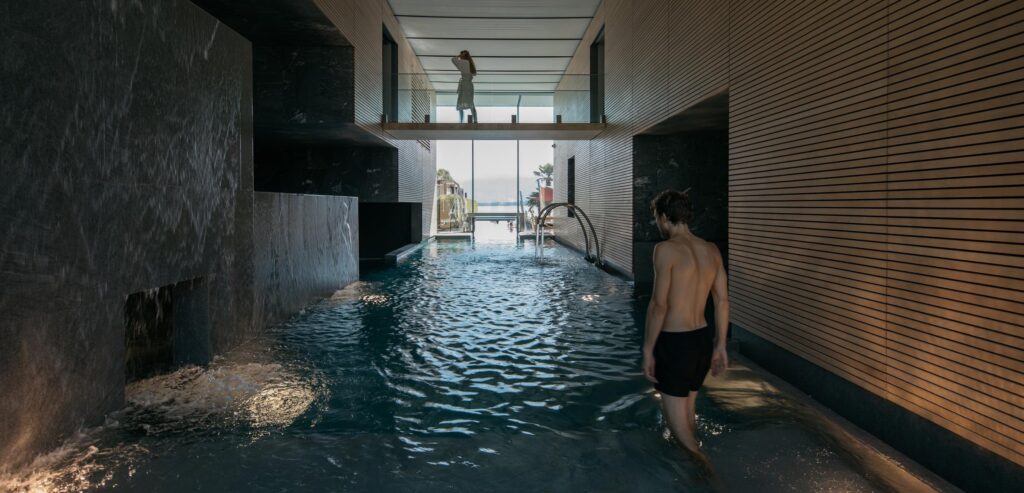 Homme entrant dans le bassin intérieur du bain thermal Termalini Salini Spa à Locarno dans les Alpes suisses