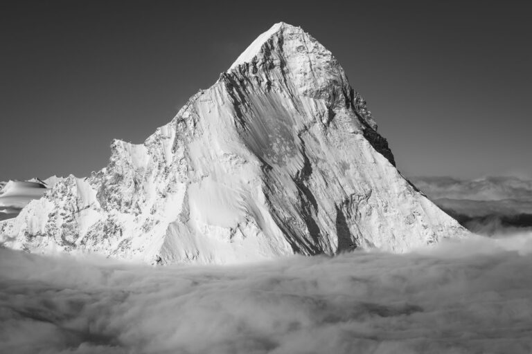 Photographie noir et blanc de la Dent Blanche dans les Alpes valaisannes émergeant d'une mer de nuages après une tempête