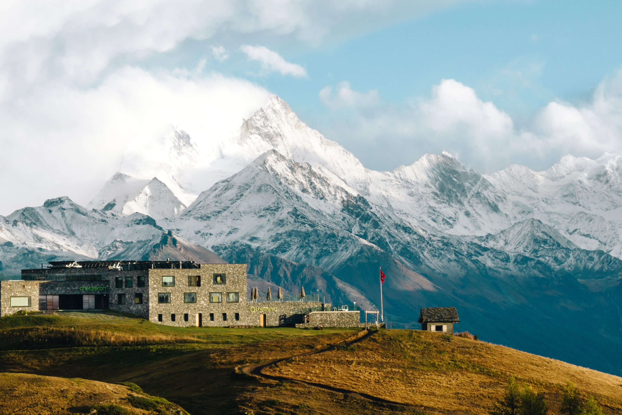 Vue sur l'hôtel Chetzeron et la chaîne de montagnes de la Couronne Impériale de Zinal en arrière-plan encore enneigée