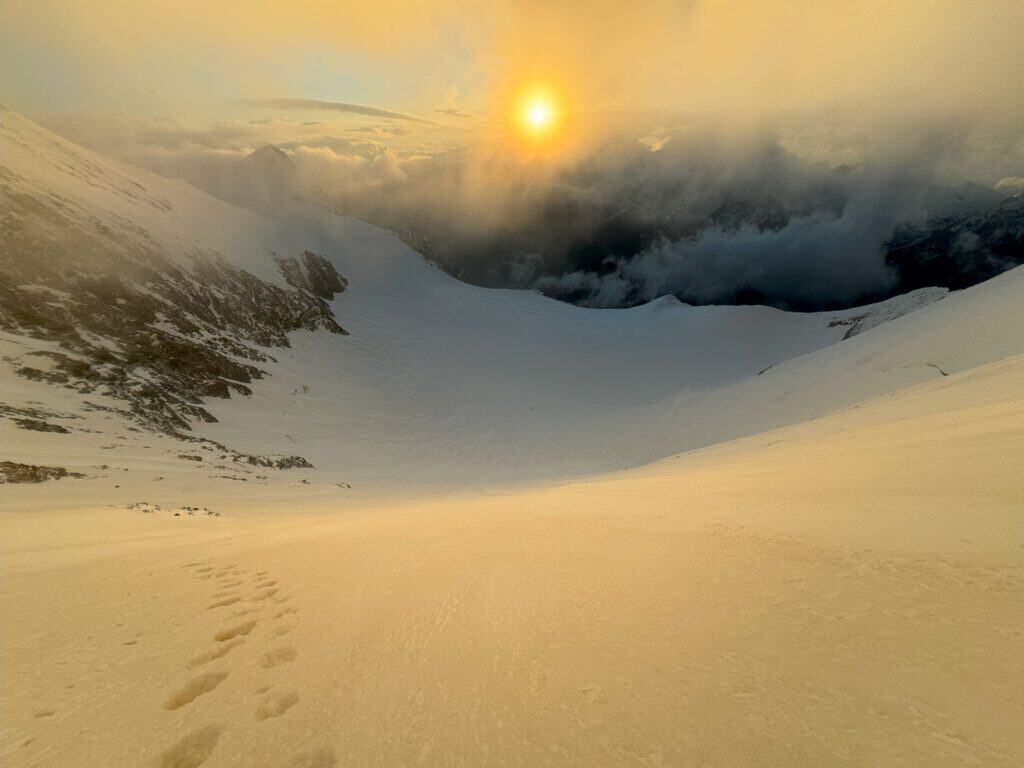 Vue sur une pente de neige de la Lenzspitze avec lever de soleil à l'horizon