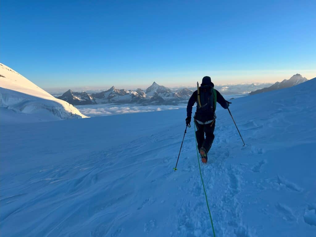 Alpiniste sur un glacier avec vue sur les Alpes valaisannes en arrière-plan