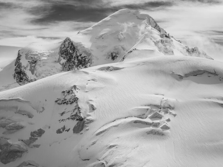 Photgraphie en noir et blanc du Mont Blanc et Dôme du Goûter, vagues de neige façonnées par le vent