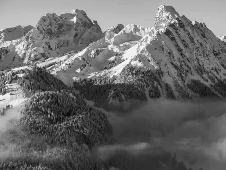 Schwarz-Weiß-Fotografie des Rubli und der Gummfluh in Gstaad, verschneite Alpengipfel im Winter.